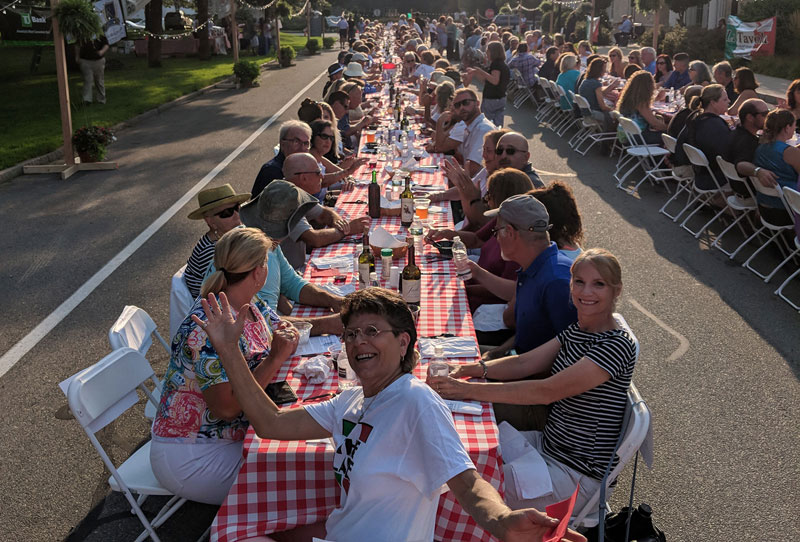 people dinning outside streets long table cape cod island