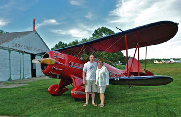 couples taking photo infront red plane cape cod island